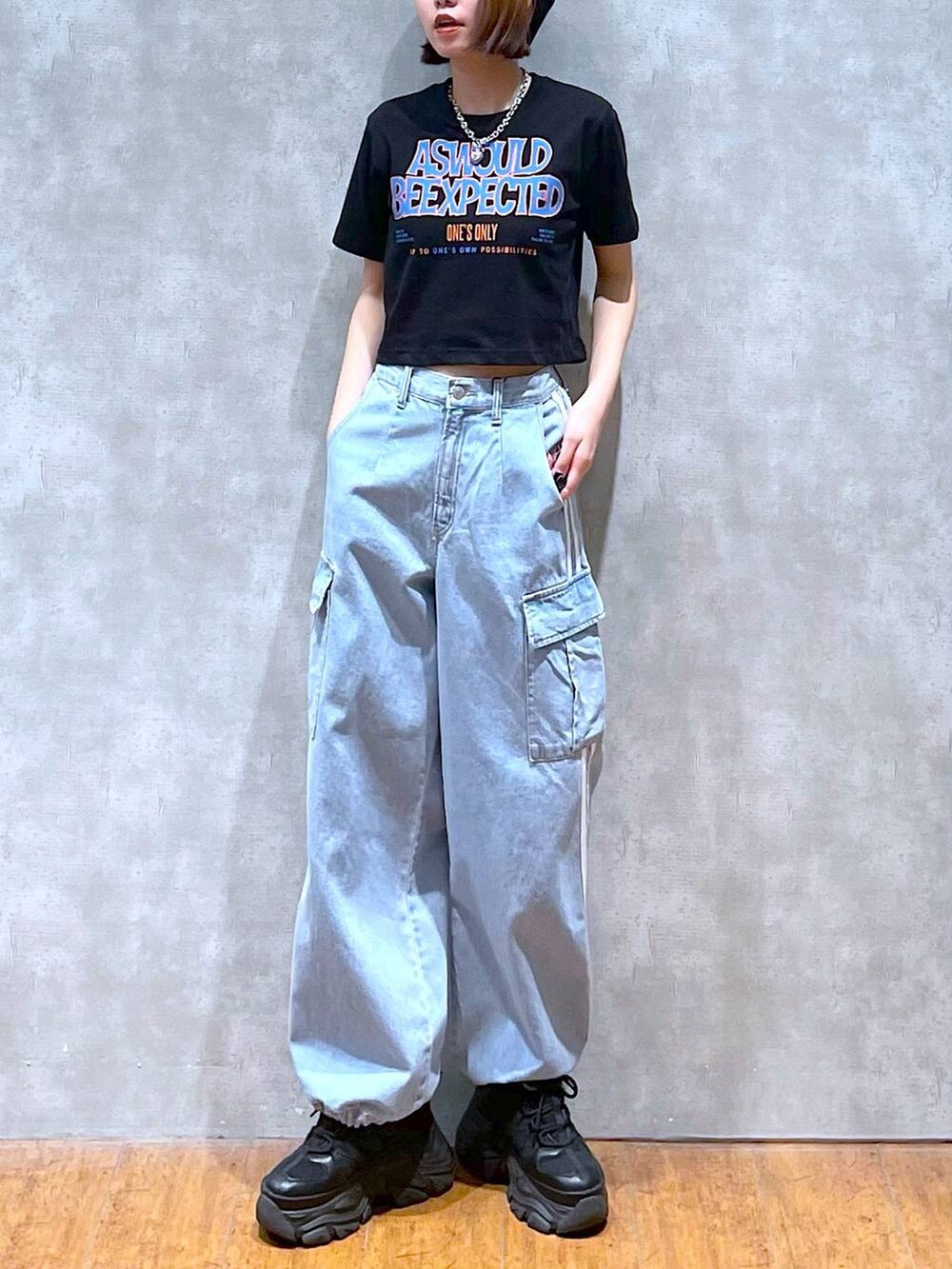 ブラック系のスニーカー、ブルー系のデニムパンツ、ブラック系のTシャツ/カットソーを着用したレディースの夏コーディネートの2枚目の写真