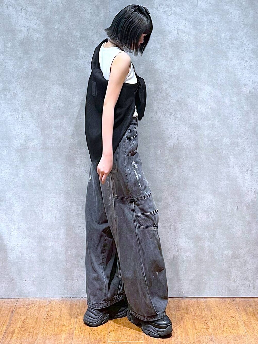 ブラック系のスニーカー、ホワイト系のタンクトップ、ブラック系のデニムパンツを着用したレディースの夏コーディネートの9枚目の写真