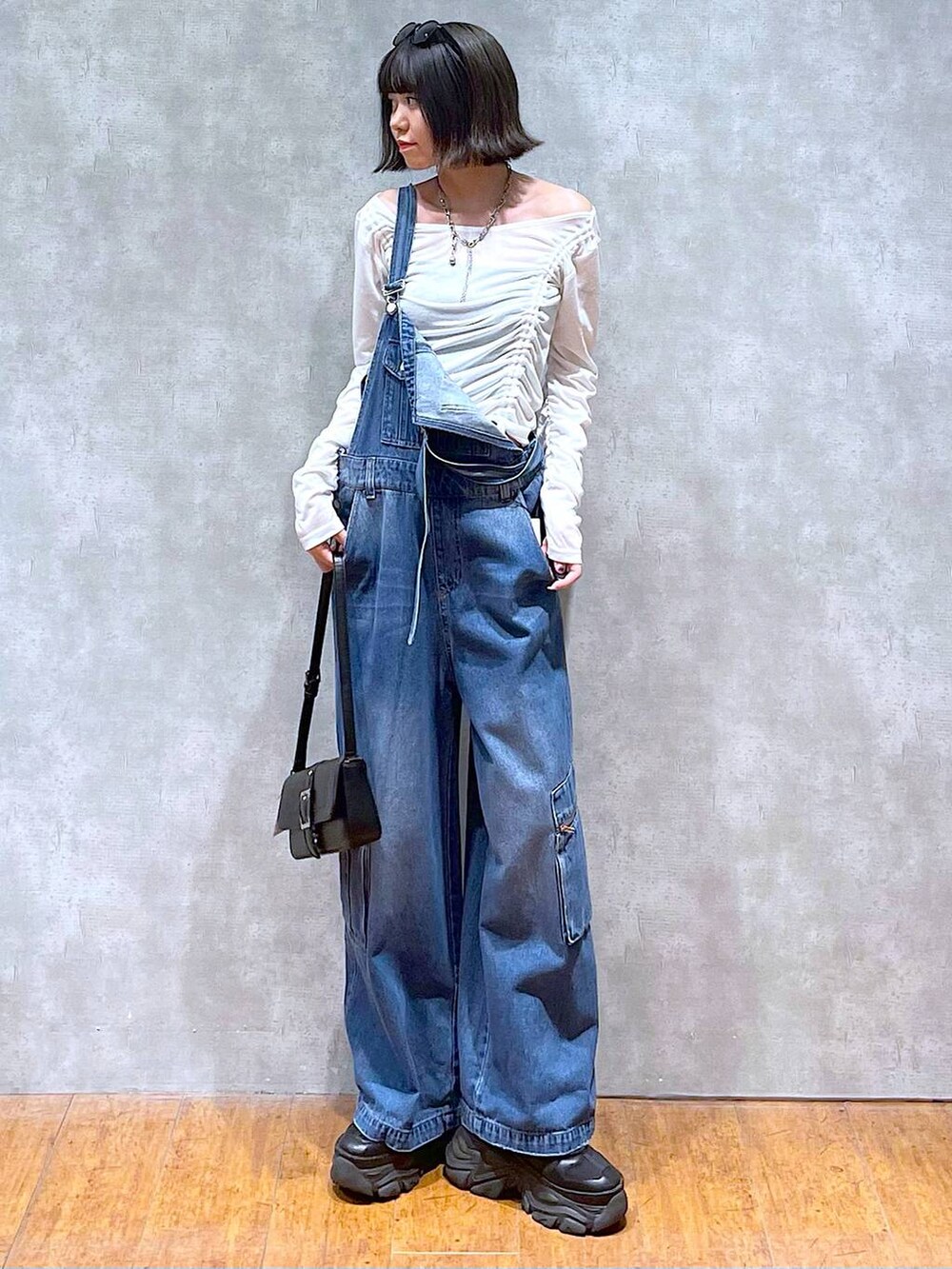 ブラック系のスニーカー、ブラック系のハンドバッグ、ブルー系のサロペット/オーバーオールを着用したレディースの夏コーディネートの6枚目の写真