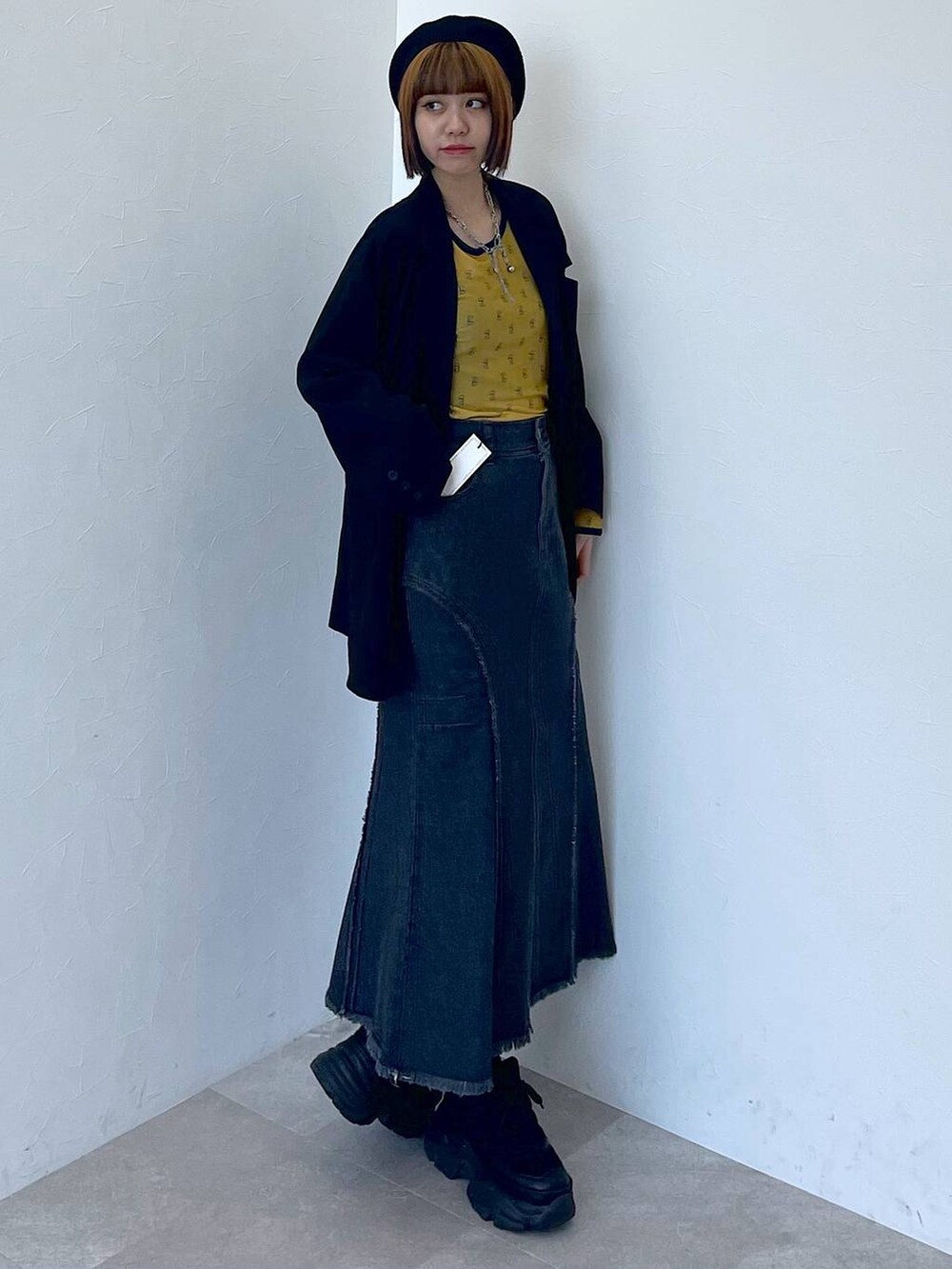 ブラック系のスニーカー、ブラック系のデニムスカート、イエロー系のTシャツ/カットソーを着用したレディースの夏コーディネートの3枚目の写真