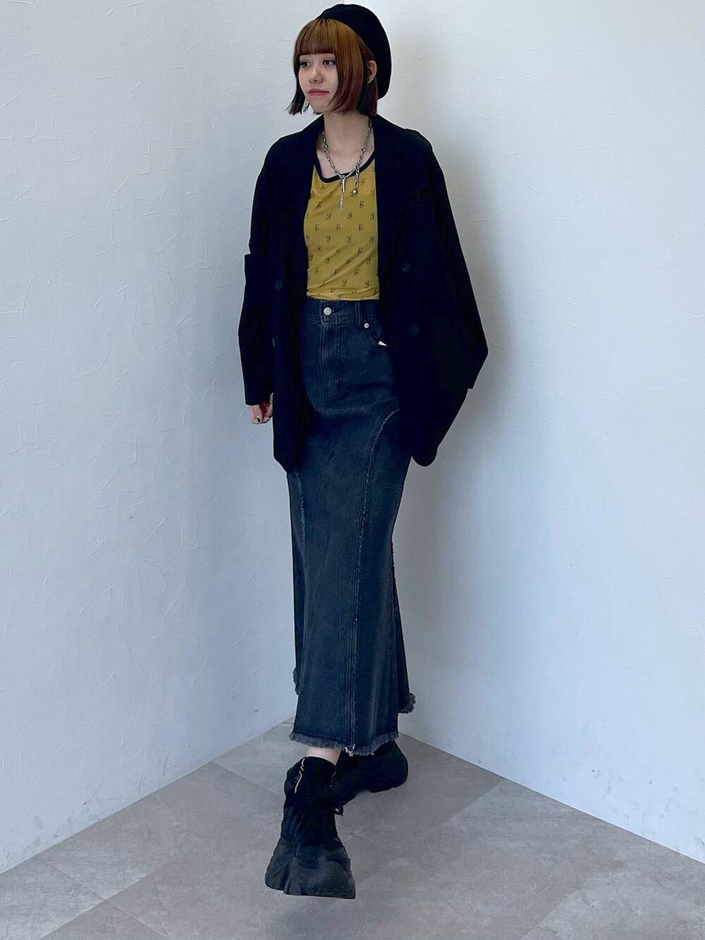 ブラック系のスニーカー、ブラック系のデニムスカート、イエロー系のTシャツ/カットソーを着用したレディースの夏コーディネートの5枚目の写真