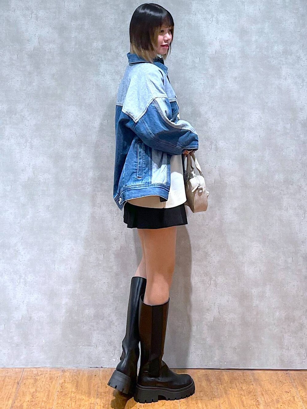 ホワイト系のニット/セーター、ブルー系のデニムジャケット、ブラック系のブーツを着用したレディースの冬コーディネートの5枚目の写真