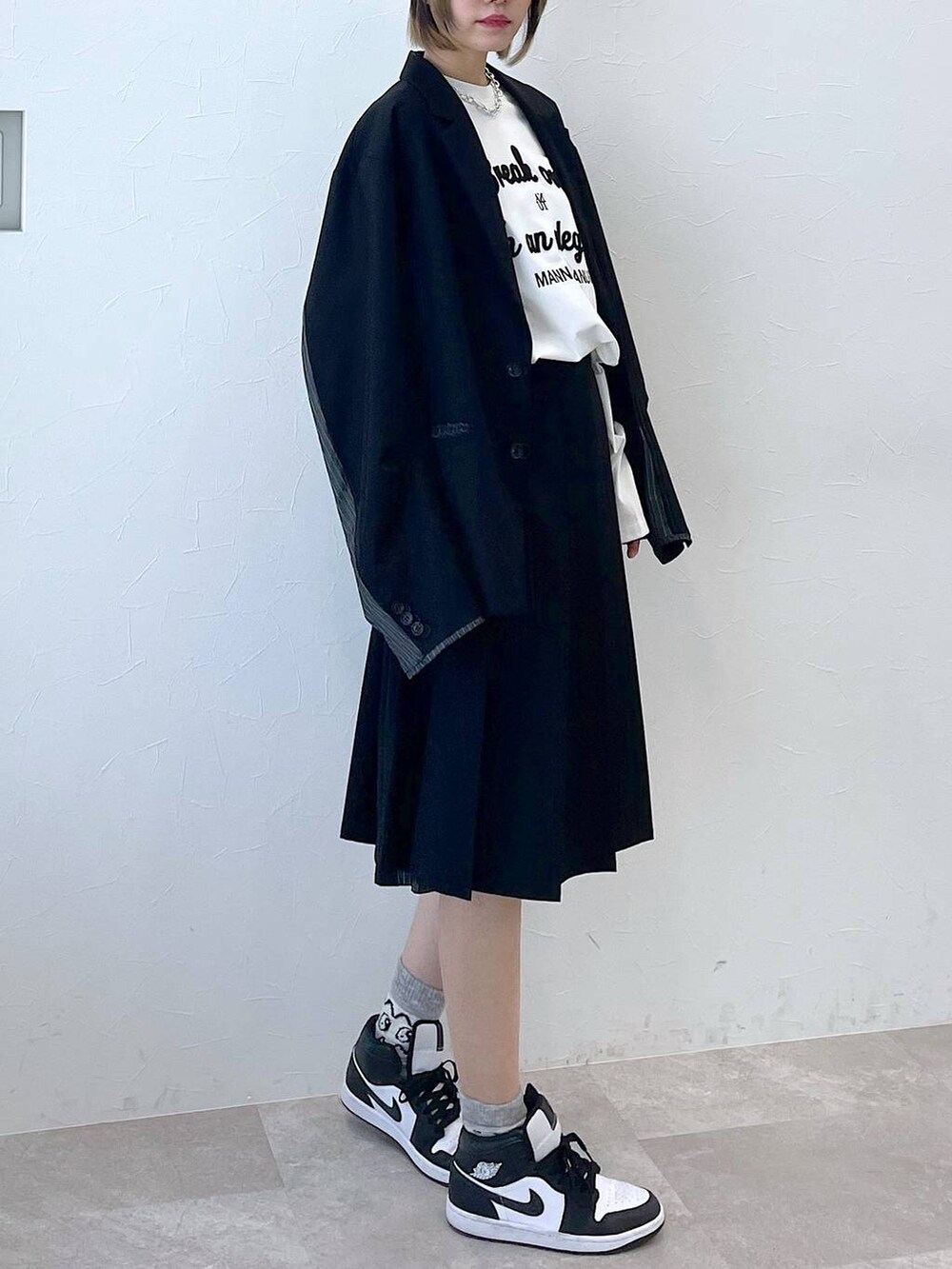 ブラック系のテーラードジャケット、ブラック系のスラックス、ブラック系のキャップを着用したレディースの冬コーディネートの3枚目の写真