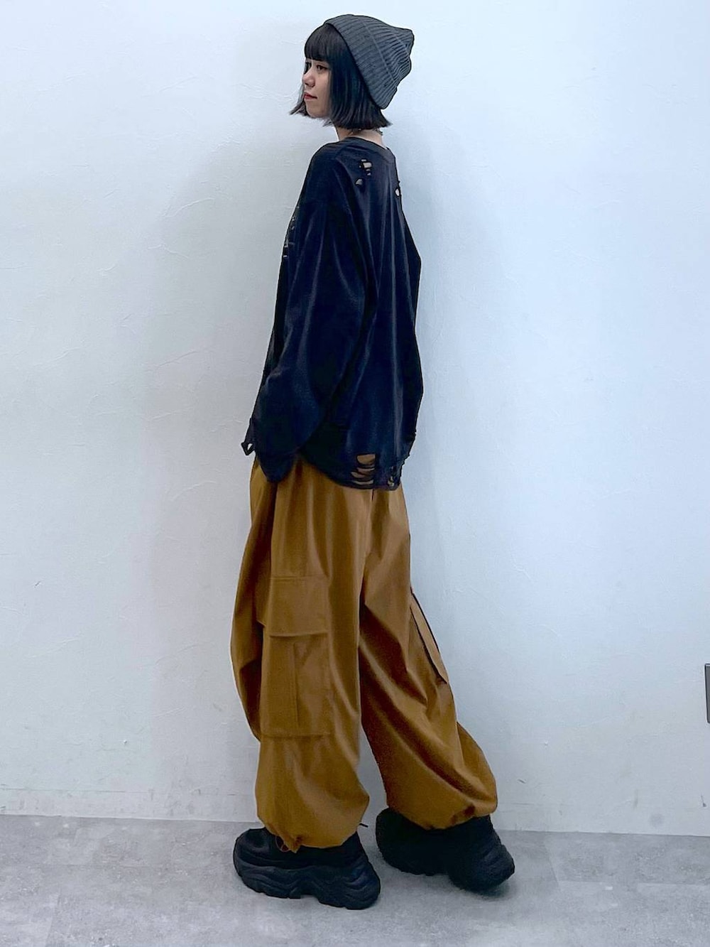 ブラック系のスニーカー、ブラウン系のカーゴパンツ、ブラック系のTシャツ/カットソーを着用したレディースの夏コーディネートの3枚目の写真