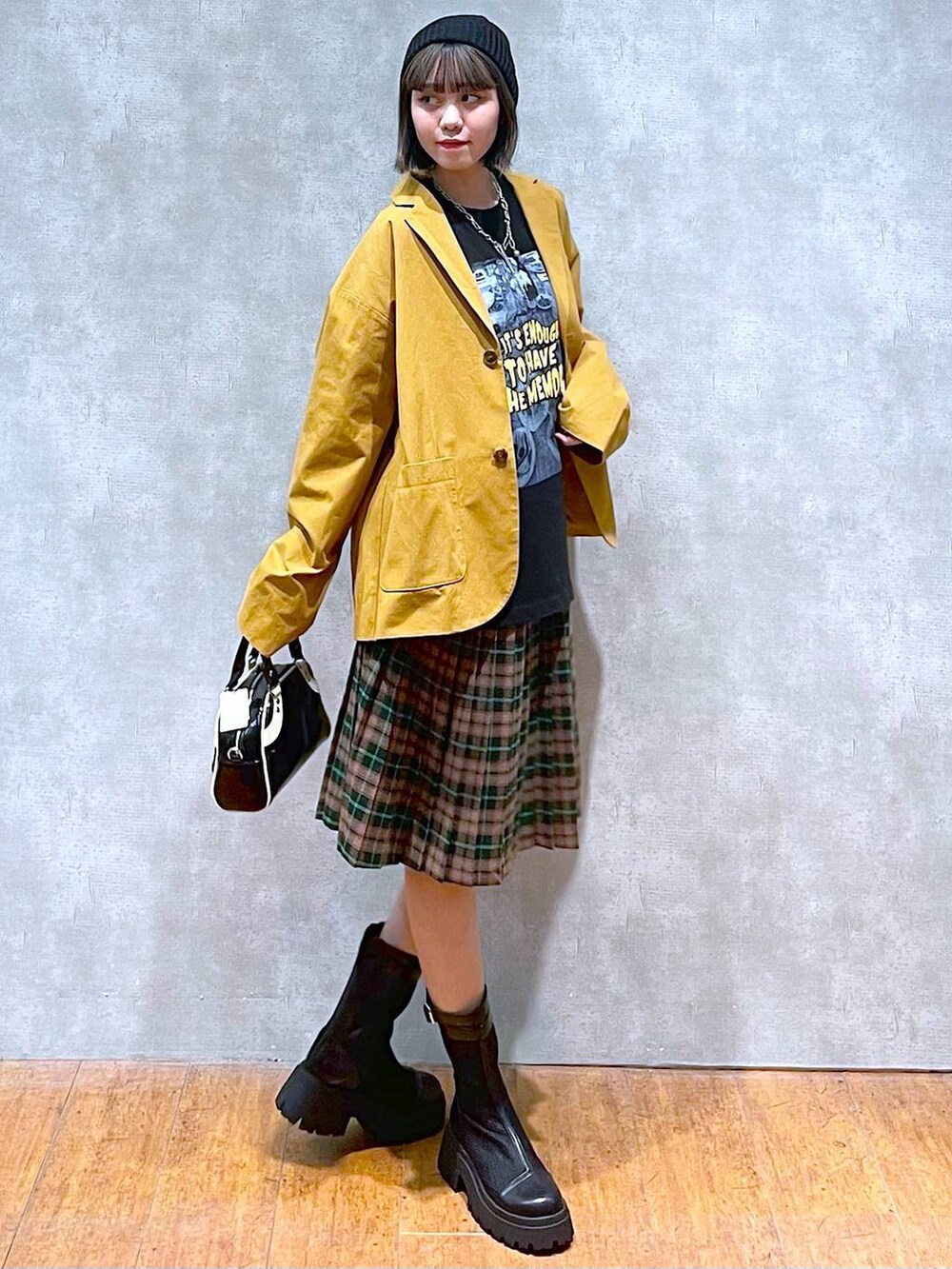 ブラック系のブーツ、ブラック系のショルダーバッグ、ブラック系のTシャツ/カットソーを着用したレディースの秋コーディネートの2枚目の写真