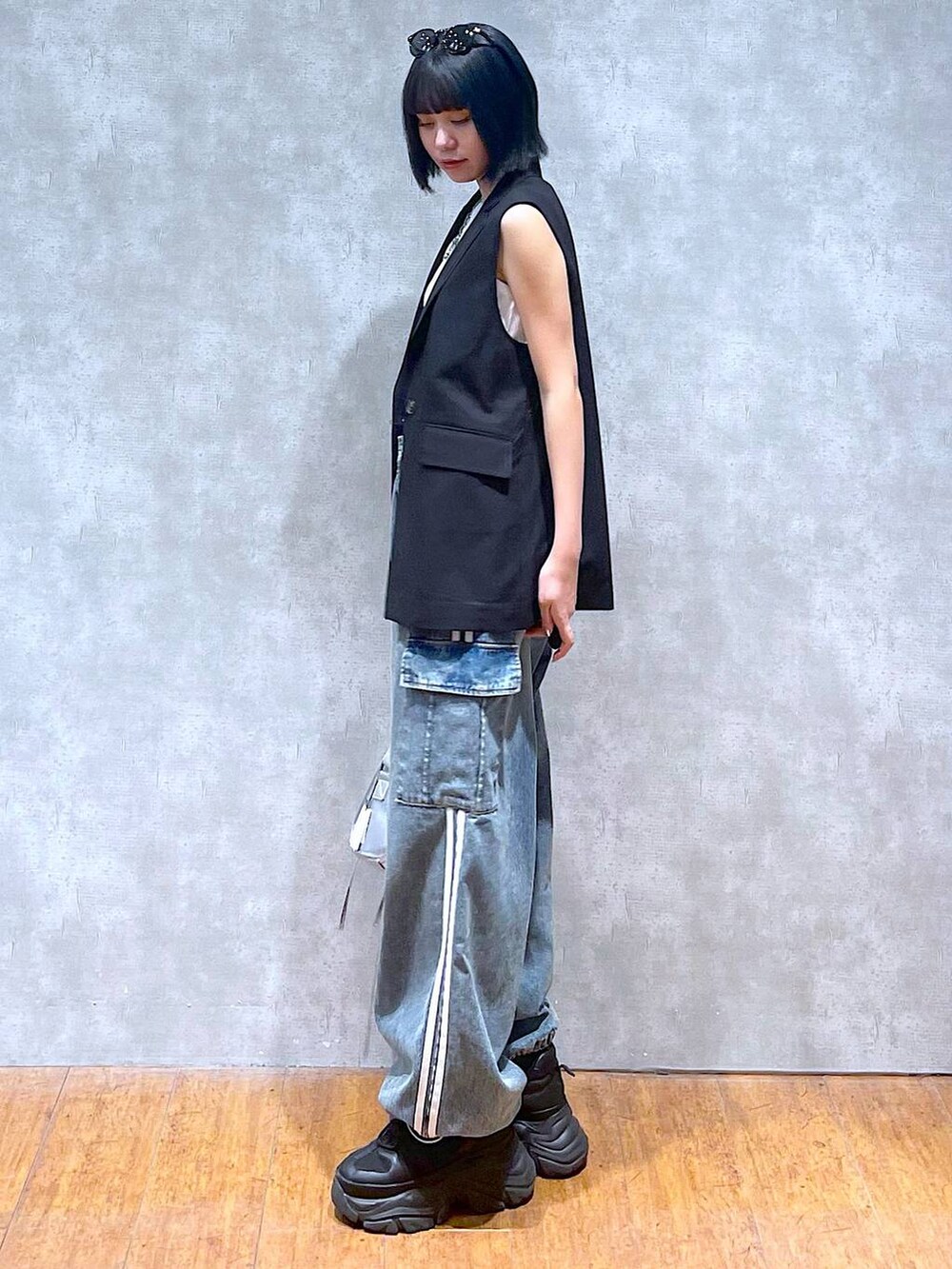 ブラック系のスニーカー、ブルー系のデニムパンツ、ホワイト系のタンクトップを着用したレディースの夏コーディネートの7枚目の写真