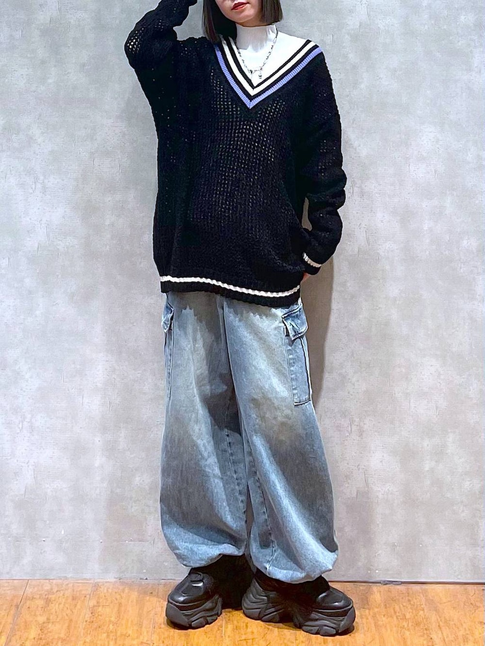 ブラック系のスニーカー、ブルー系のデニムパンツ、ブラック系のニット/セーターを着用したレディースの秋コーディネートの2枚目の写真