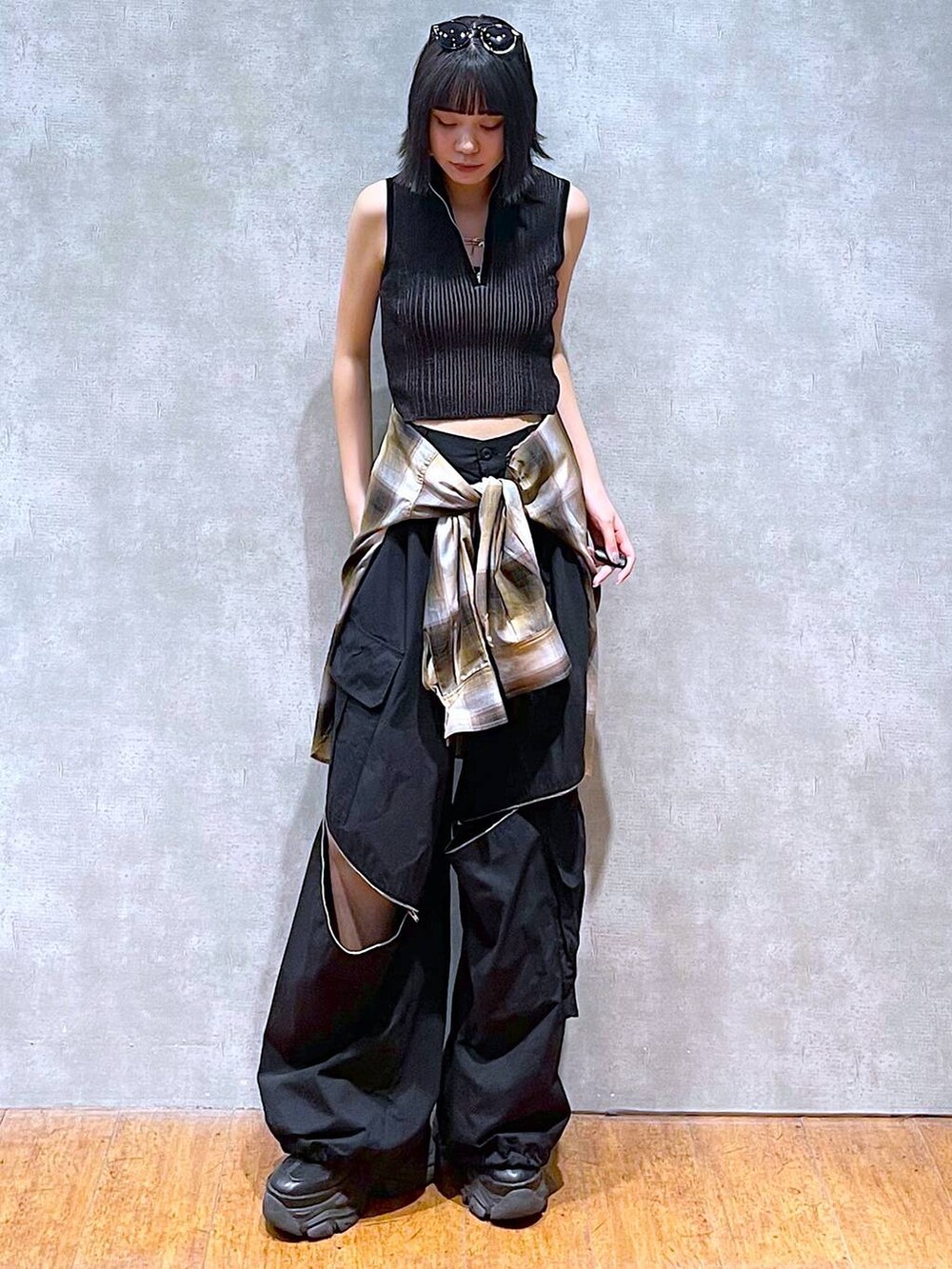 ブラック系のスニーカー、ブラック系のニット/セーター、ブラック系のカーゴパンツを着用したレディースの秋コーディネートの3枚目の写真