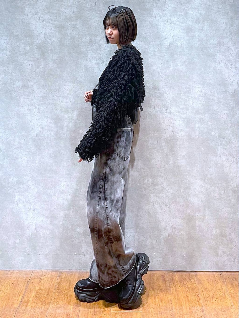 ブラック系のスニーカー、ブラック系のショルダーバッグ、ブラック系のデニムパンツを着用したレディースの秋コーディネートの3枚目の写真