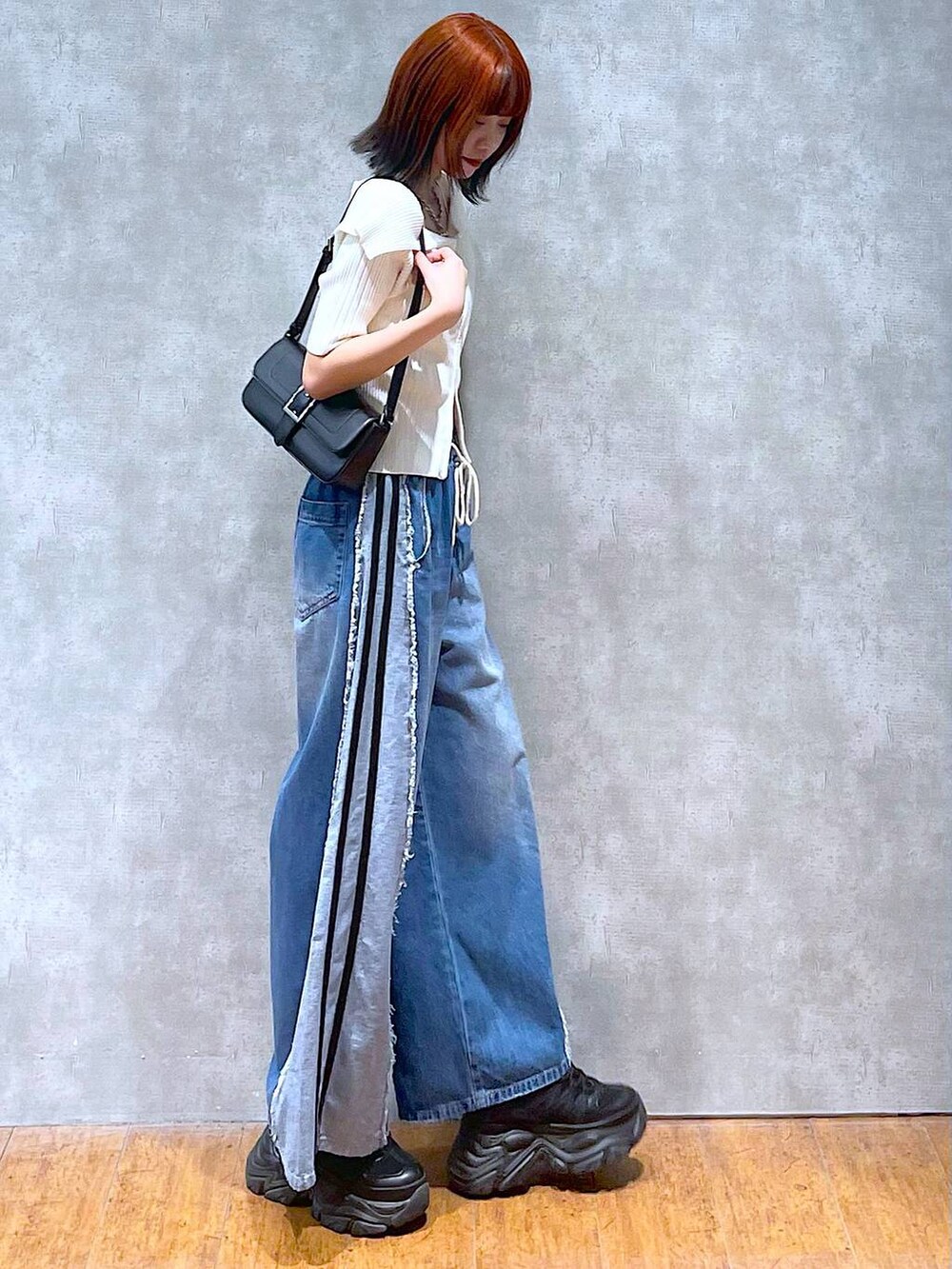 ブラック系のスニーカー、ホワイト系のニット/セーター、ホワイト系のキャミソールを着用したレディースの夏コーディネートの5枚目の写真