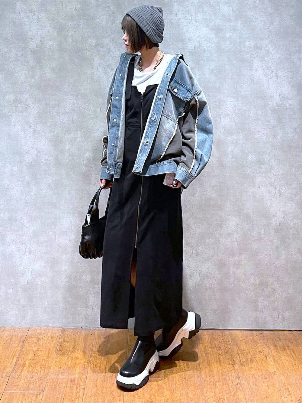 ブルー系のブルゾン、ブラック系のハンドバッグ、ホワイト系のTシャツ/カットソーを着用したレディースの秋コーディネートの5枚目の写真