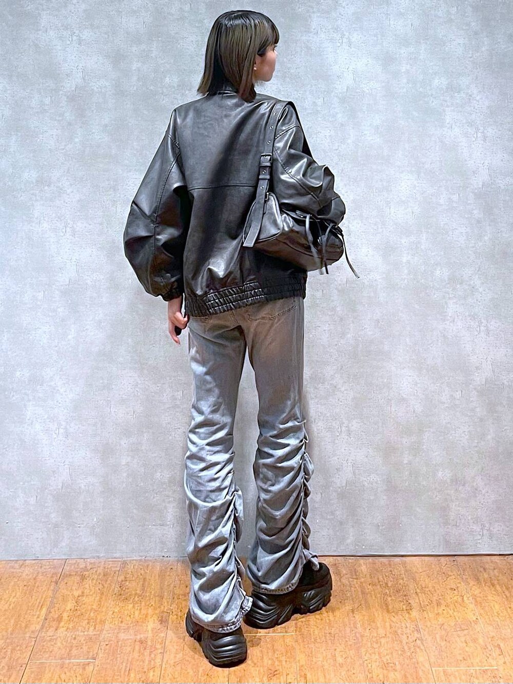 ブラック系のスニーカー、ブラック系のショルダーバッグ、ブルー系のデニムパンツを着用したレディースの秋コーディネートの8枚目の写真