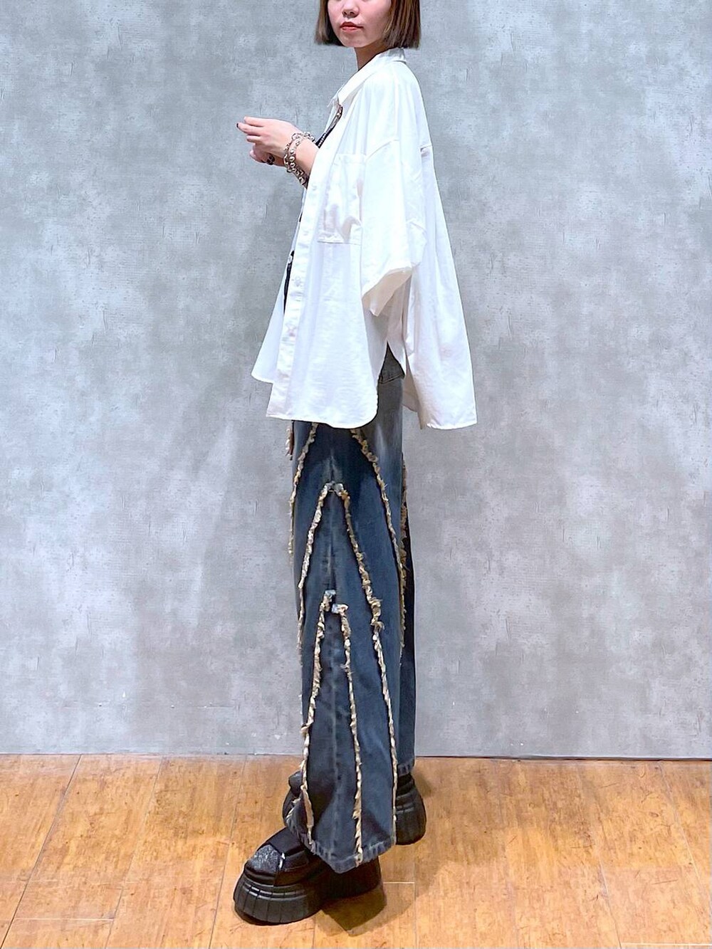 ブラック系のスニーカー、ブラック系のキャミソール、ホワイト系のシャツ/ブラウスを着用したレディースの夏コーディネートの3枚目の写真