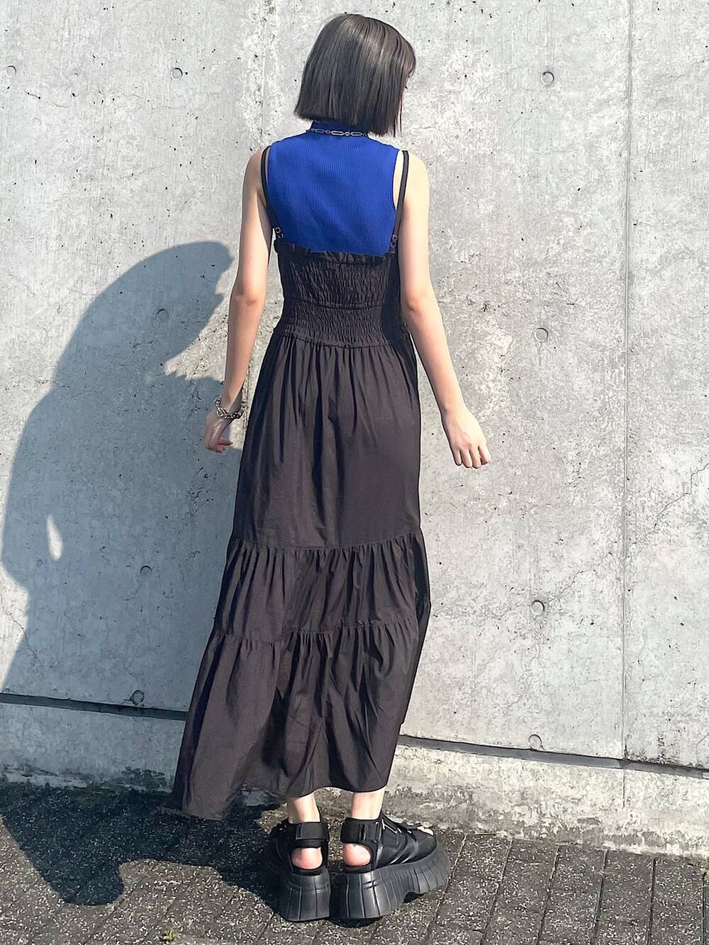 ブラック系のスニーカー、ブラック系のワンピース、シルバー系のネックレスを着用したレディースの夏コーディネートの5枚目の写真