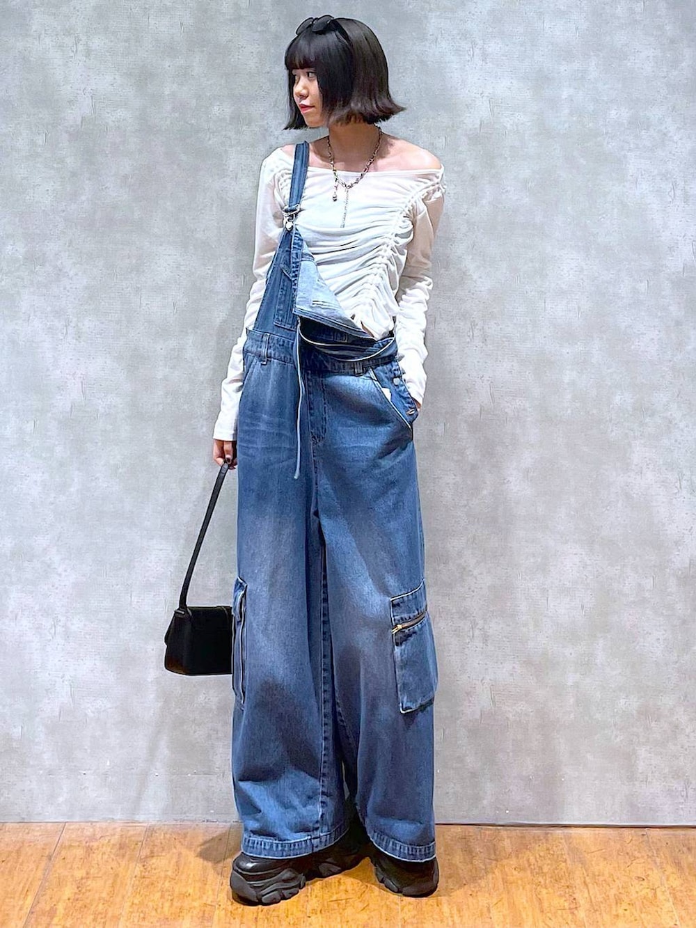 ブラック系のスニーカー、ブラック系のハンドバッグ、ブルー系のサロペット/オーバーオールを着用したレディースの夏コーディネートの7枚目の写真