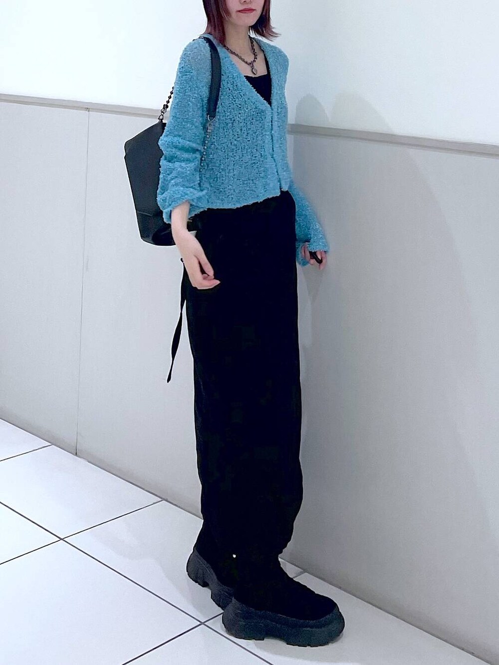 ブラック系のショルダーバッグ、ブラック系のタンクトップ、ブラック系のブーツを着用したレディースの春コーディネートの3枚目の写真