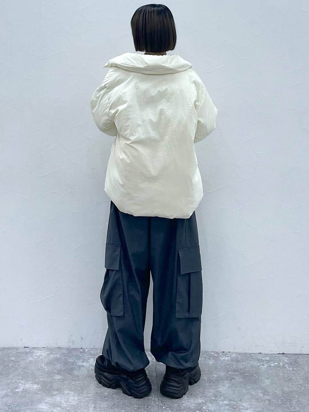 ブラック系のスニーカー、グレー系のカーゴパンツ、ホワイト系のブルゾンを着用したレディースの秋コーディネートの6枚目の写真