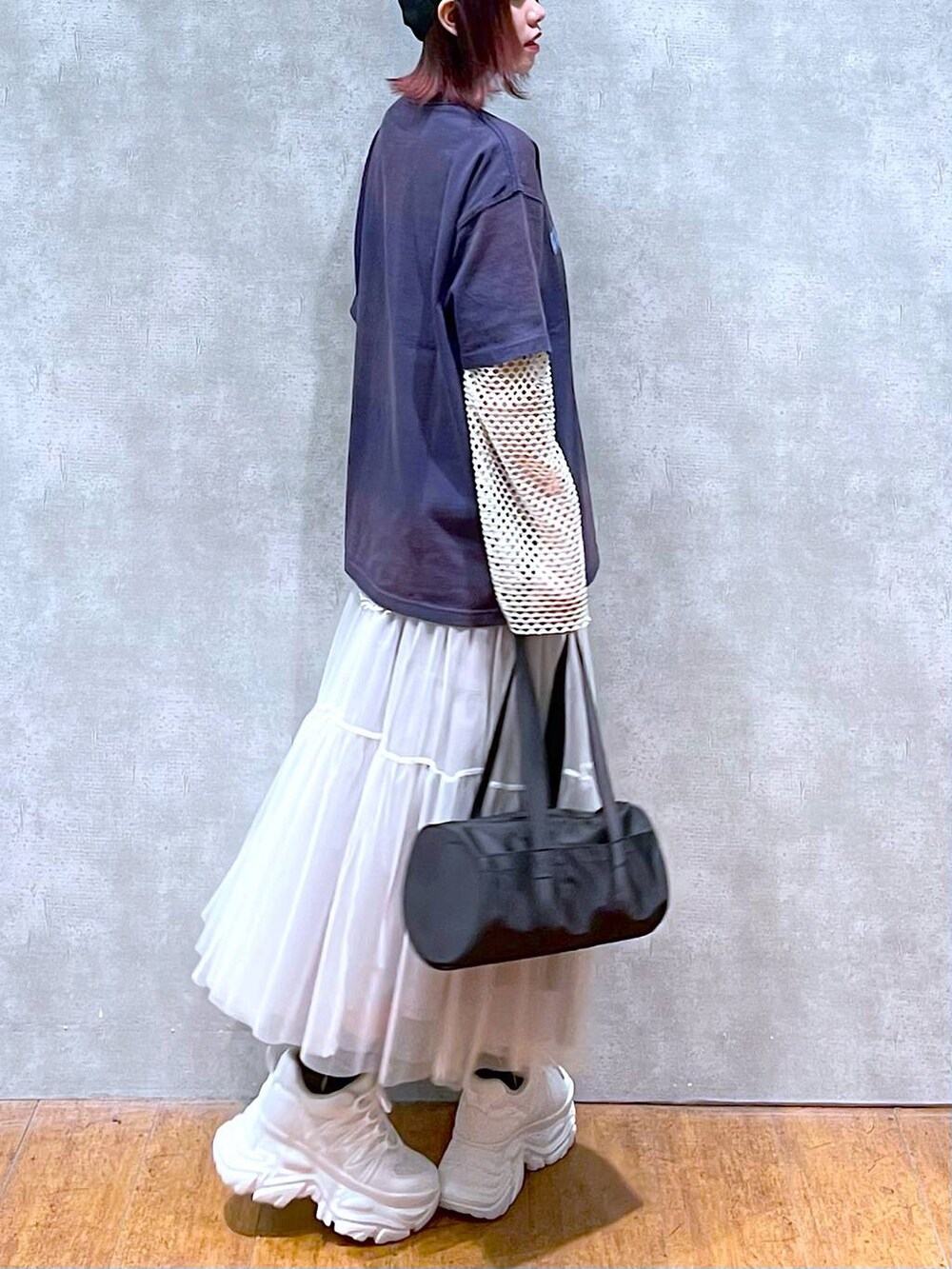 ブラック系のドラムバッグ、ホワイト系のスカート、ホワイト系のスニーカーを着用したレディースの春コーディネートの4枚目の写真