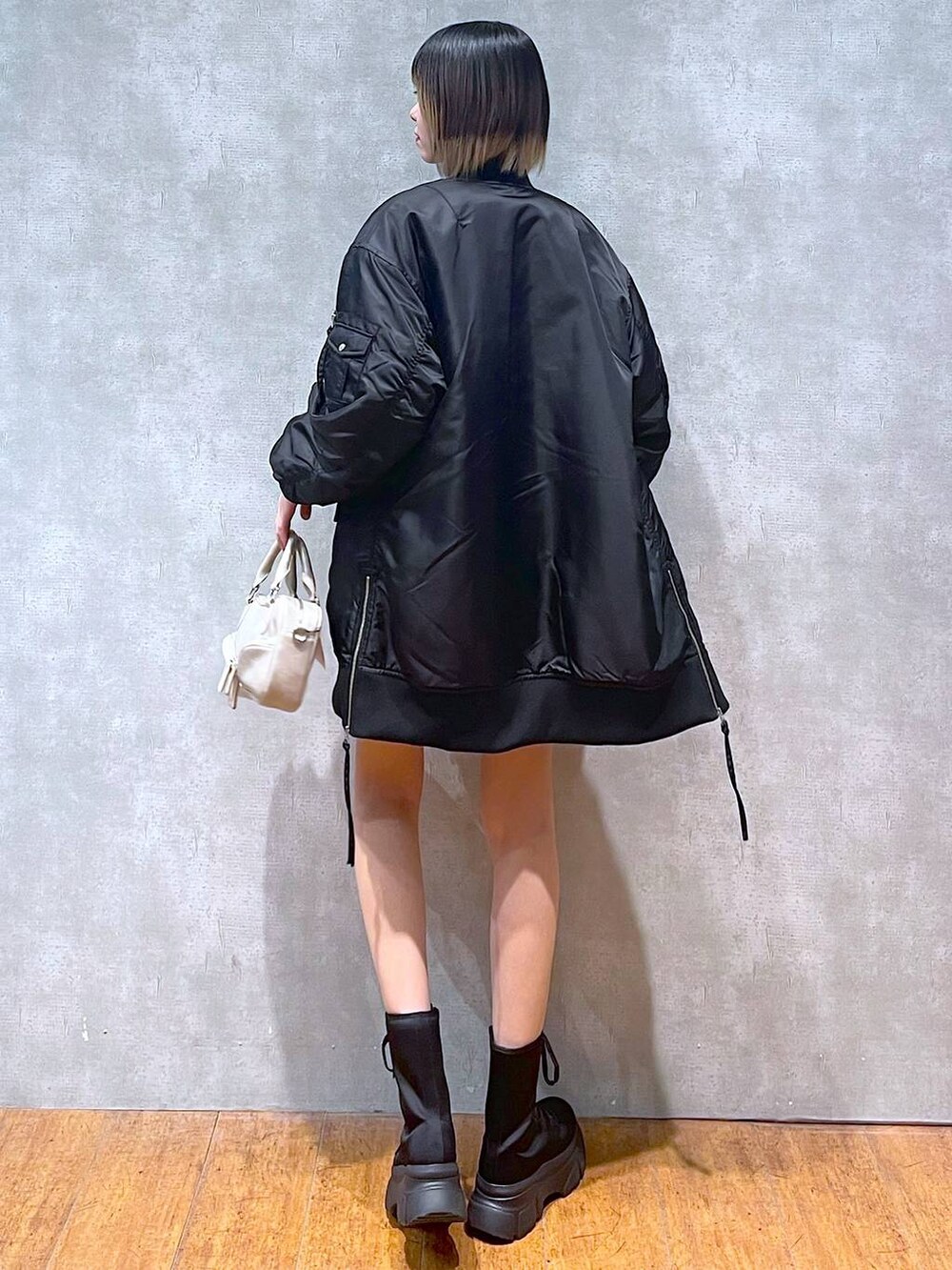 ブラック系のMA-1、ブラック系のブーツ、ブラック系のニット/セーターを着用したレディースの冬コーディネートの6枚目の写真