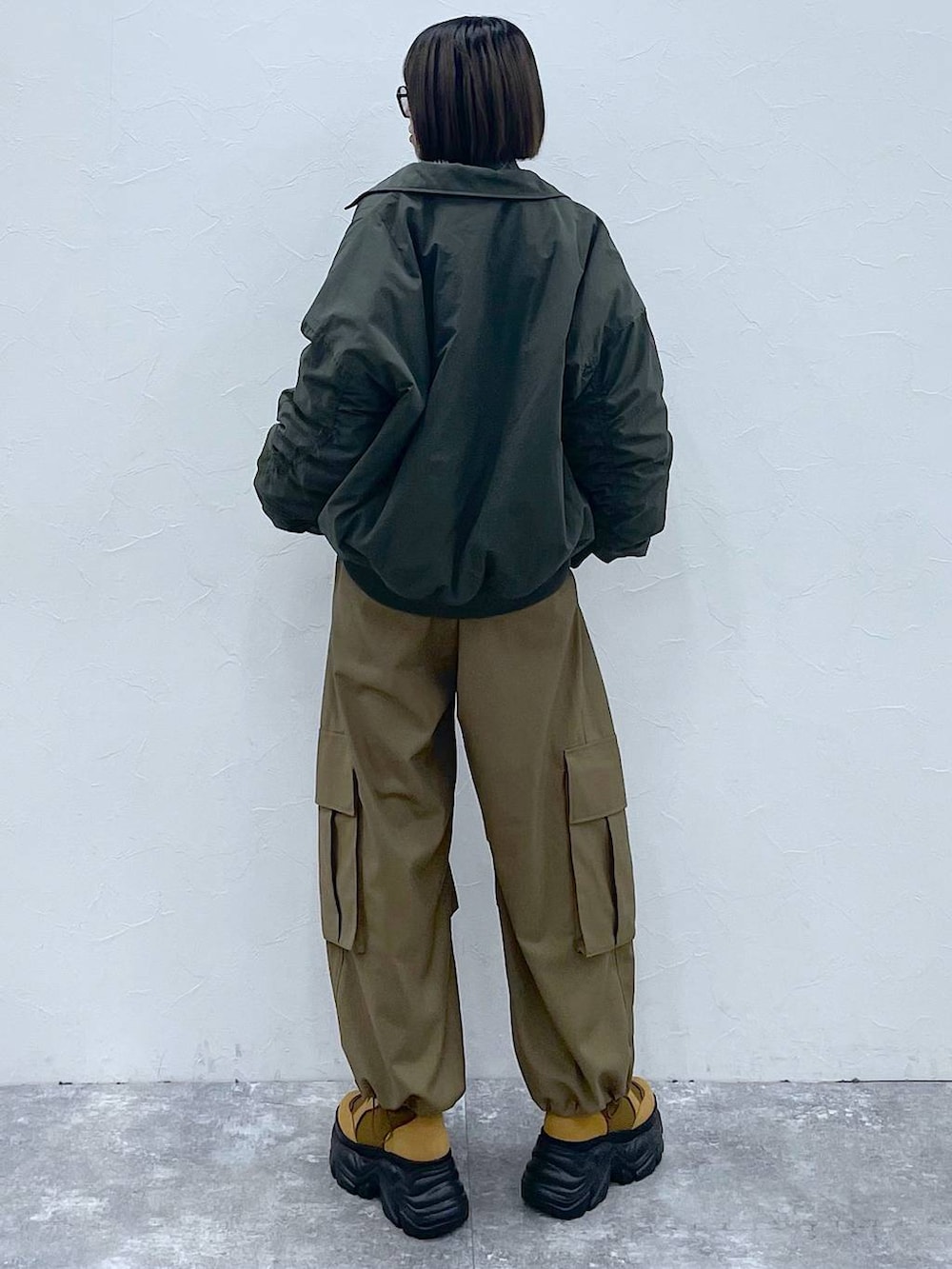 グレー系のネクタイ、ブラウン系のブーツ、グリーン系のブルゾンを着用したレディースの秋コーディネートの5枚目の写真