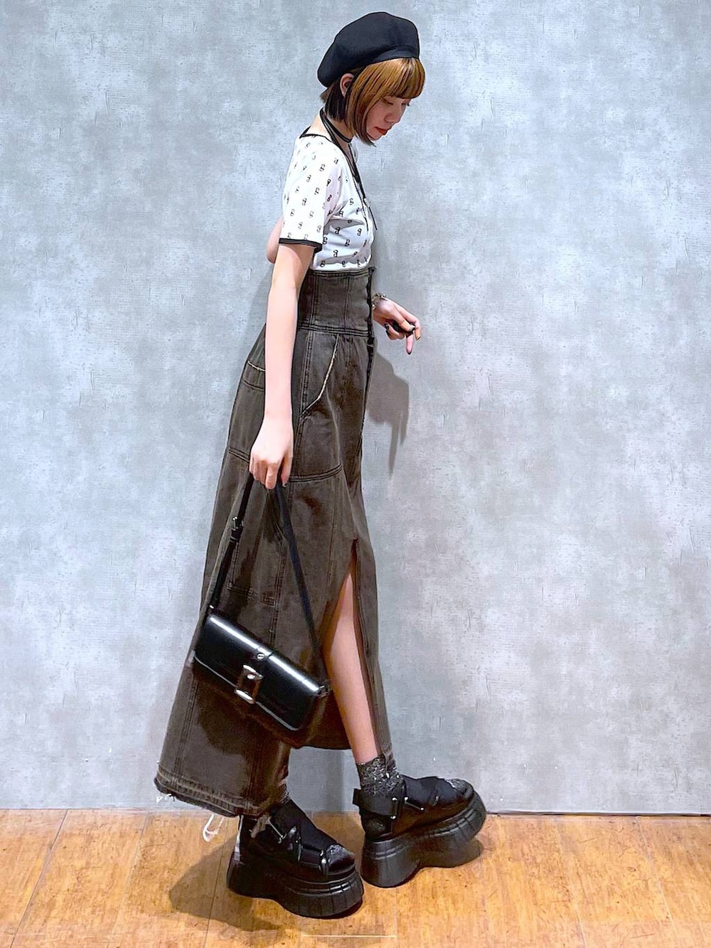 ブラック系のスニーカー、ブラック系のデニムスカート、ブラック系のハンドバッグを着用したレディースの夏コーディネートの5枚目の写真