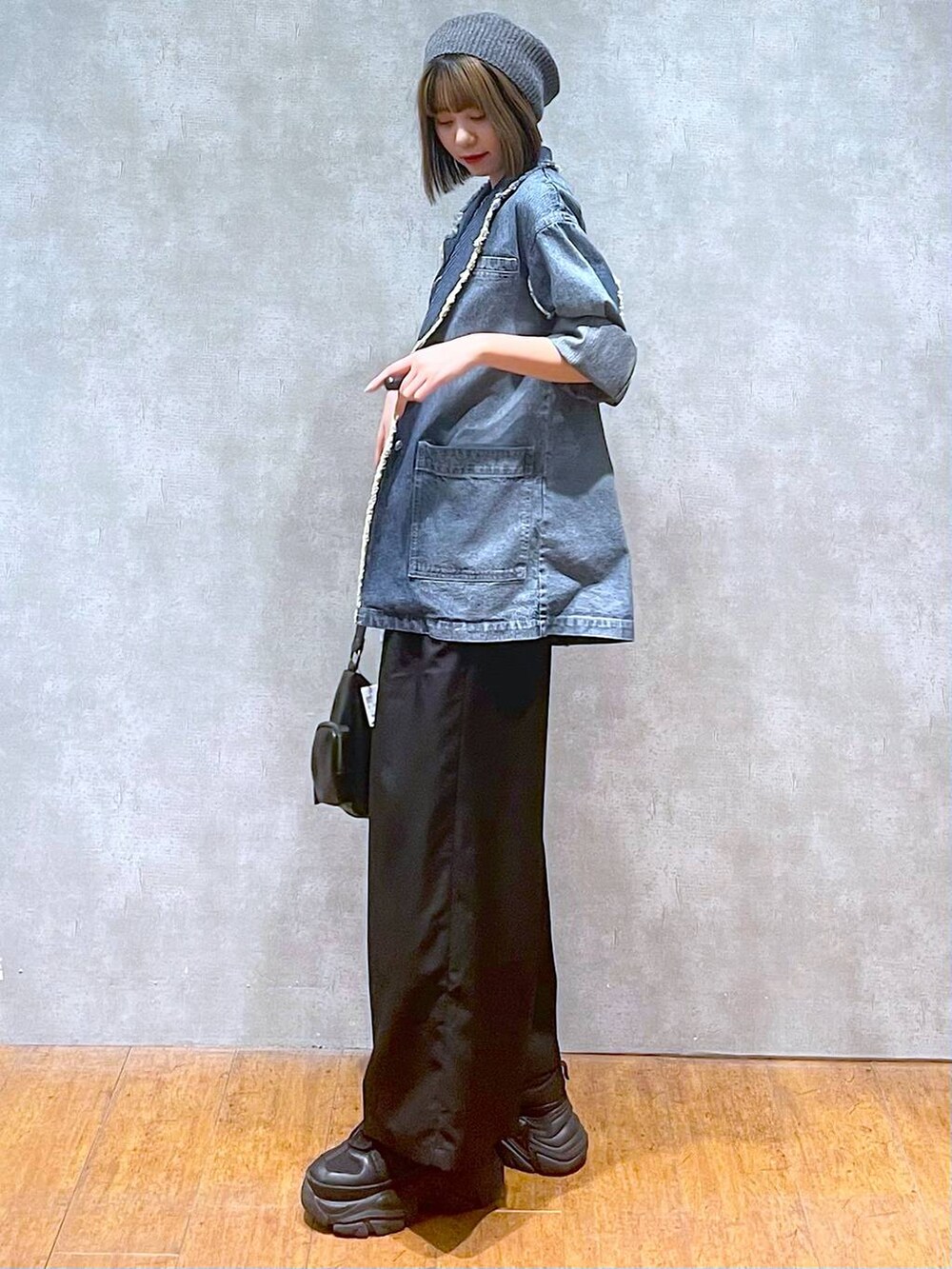 ブラック系のスニーカー、ブルー系のテーラードジャケット、ブラック系のキャミソールを着用したレディースの秋コーディネートの2枚目の写真