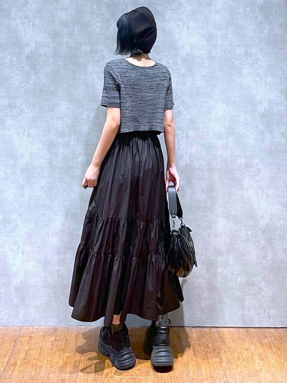 ブラック系のスニーカー、ブラック系のショルダーバッグ、ブラック系のワンピースを着用したレディースの夏コーディネートの6枚目の写真