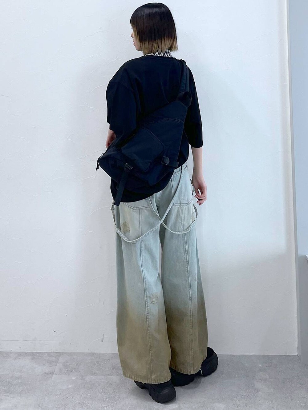 ブラック系のTシャツ/カットソー、ブラック系のボディバッグ/ウエストポーチ、ブラック系のブーツを着用したレディースの春コーディネートの7枚目の写真