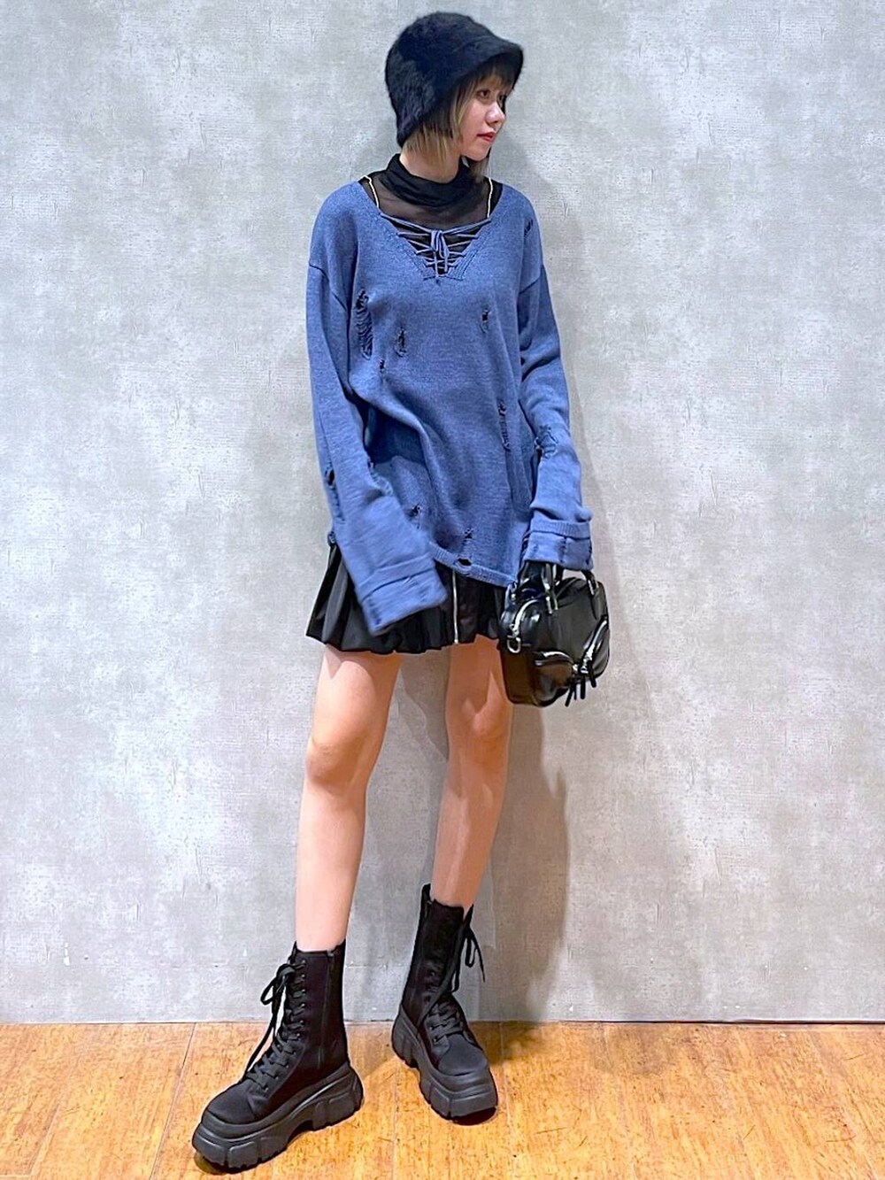 ブラック系のTシャツ/カットソー、ブラック系のスカート、ブラック系のボストンバッグを着用したレディースの冬コーディネートの3枚目の写真