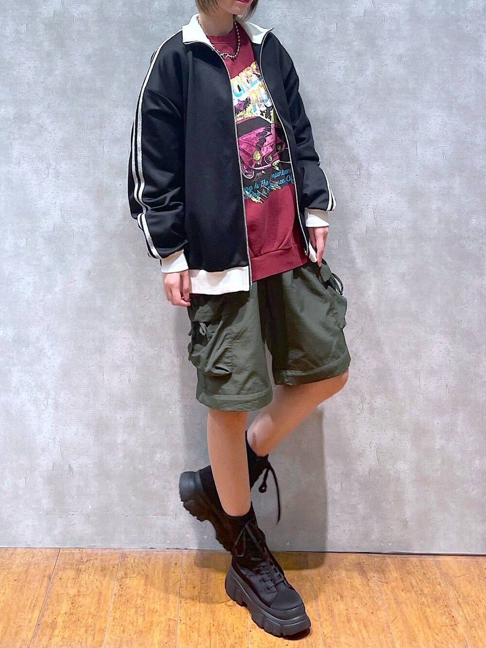 ブラック系のその他アウター、グリーン系のカーゴパンツ、ブラック系のブーツを着用したレディースの冬コーディネートの5枚目の写真