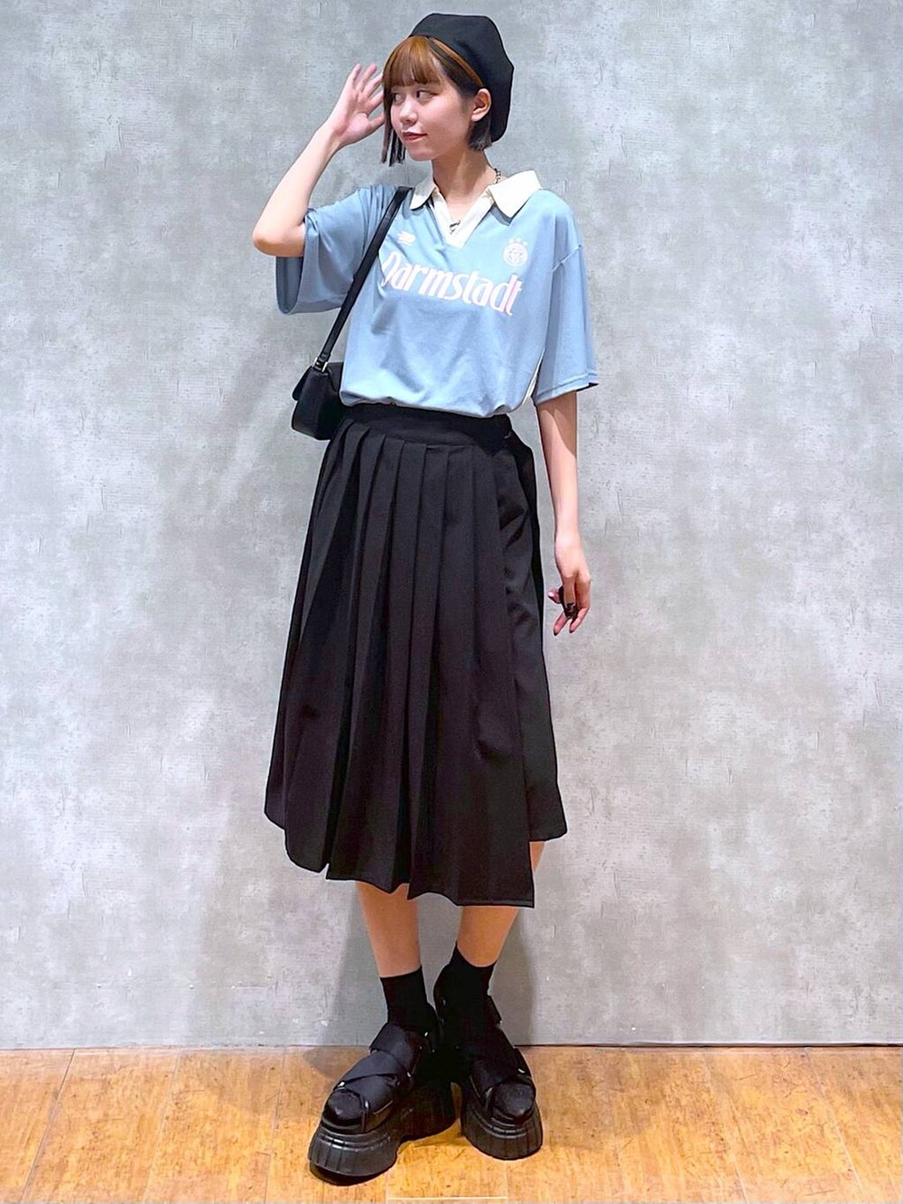 ブラック系のスニーカー、ブラック系のスカート、ブラック系のハンドバッグを着用したレディースの夏コーディネートの2枚目の写真