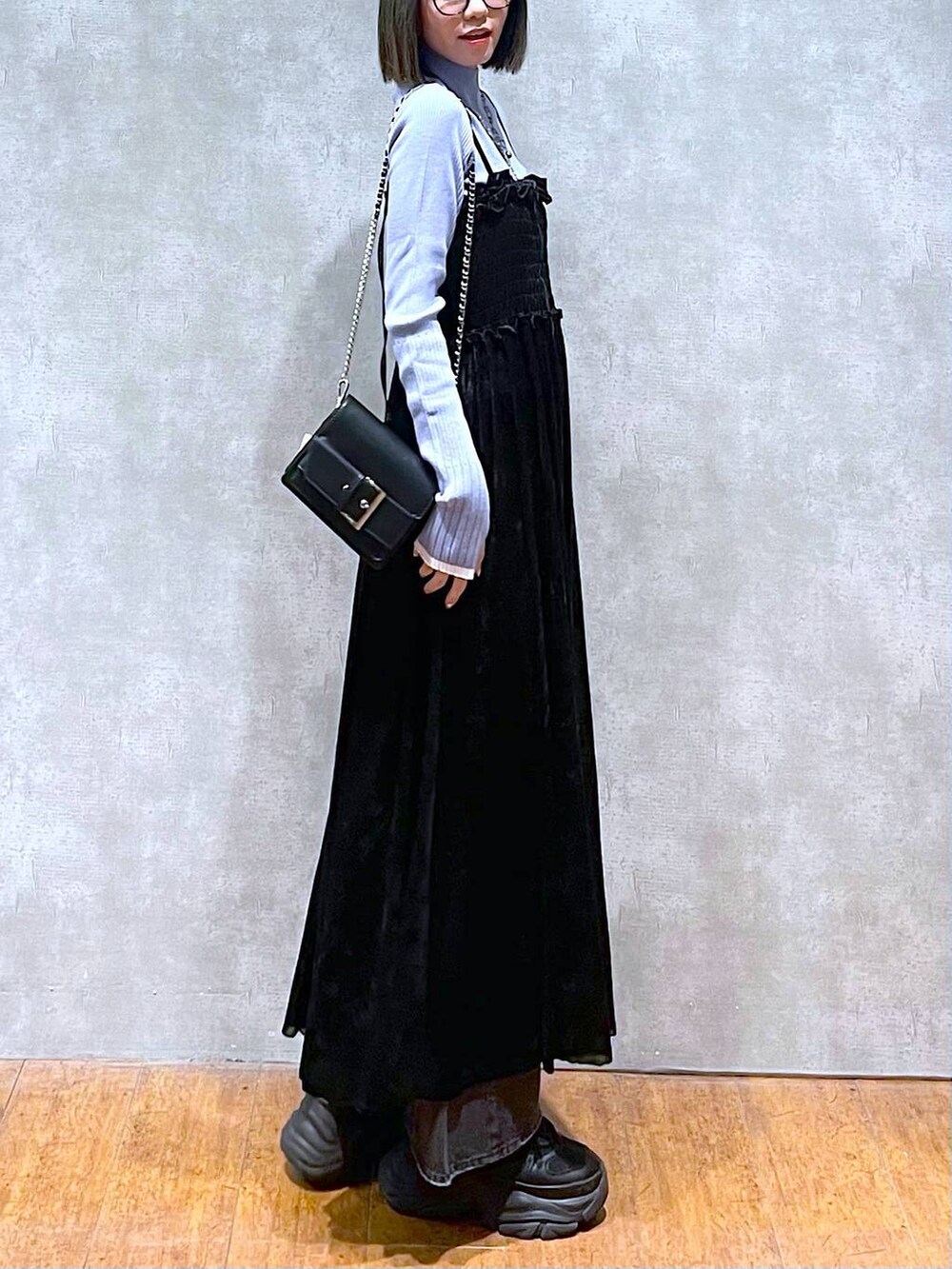 ブラック系のスニーカー、ブルー系のニット/セーター、ブラック系のデニムパンツを着用したレディースの秋コーディネートの3枚目の写真