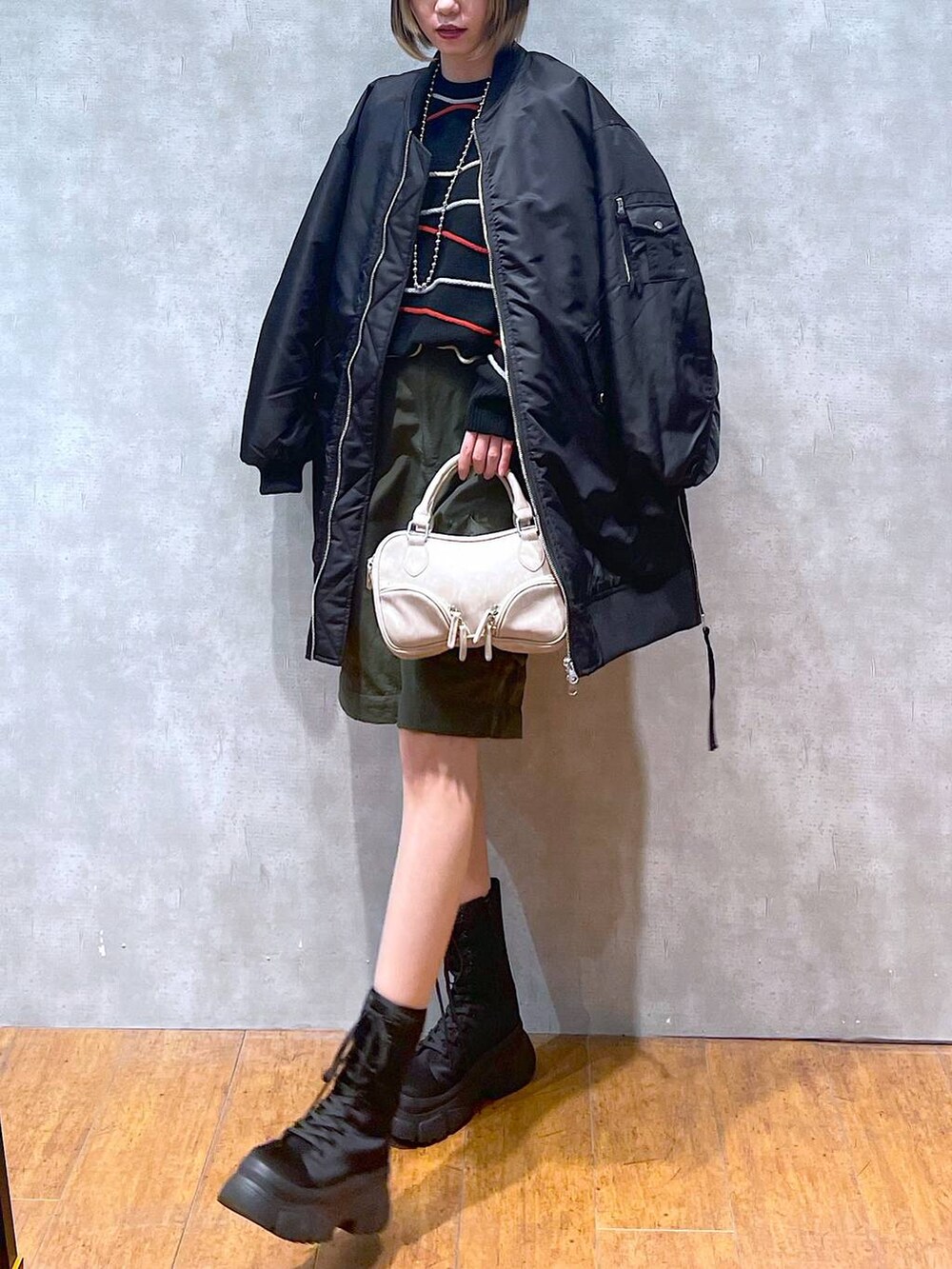 グリーン系のカーゴパンツ、ブラック系のMA-1、ブラック系のニット/セーターを着用したレディースの冬コーディネートの3枚目の写真