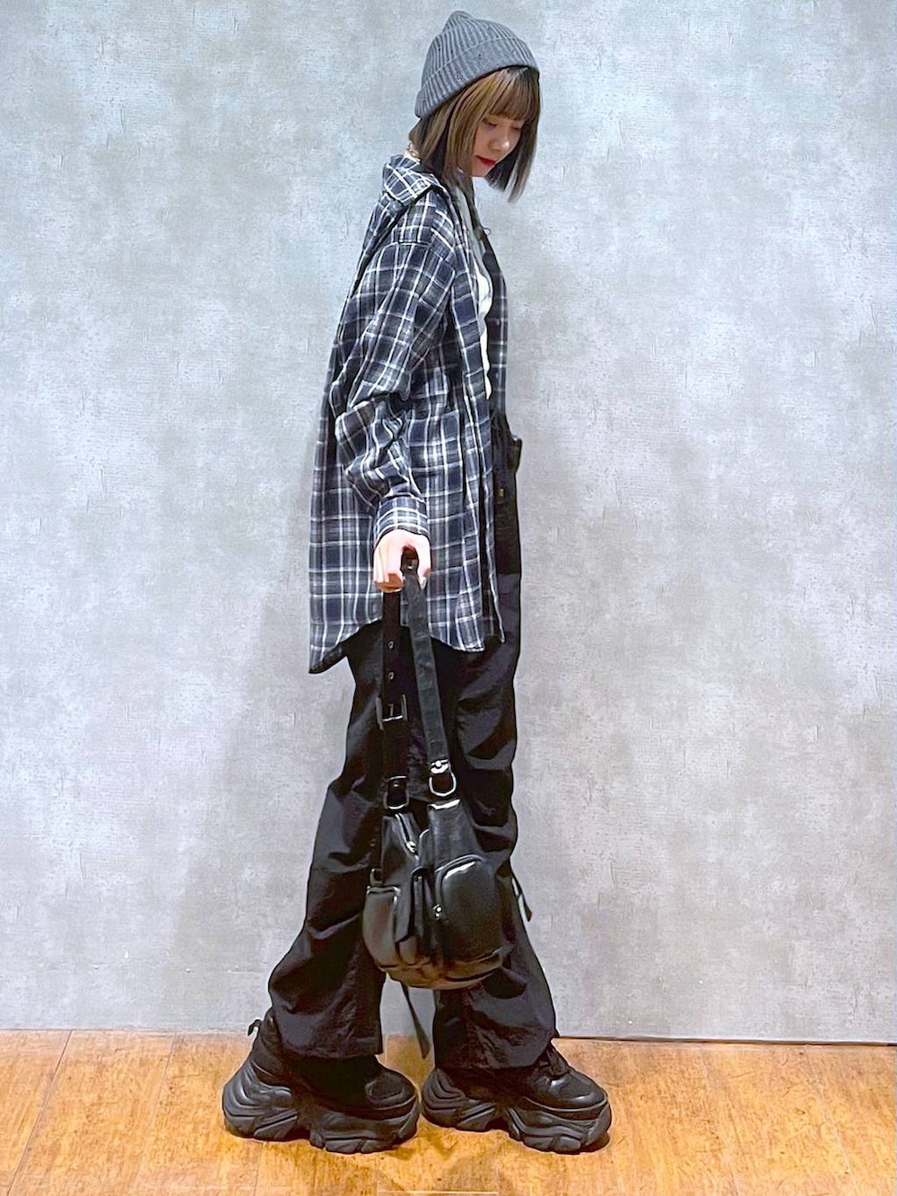 ブラック系のスニーカー、ブラック系のカーゴパンツ、ブルー系のシャツ/ブラウスを着用したレディースの秋コーディネートの2枚目の写真