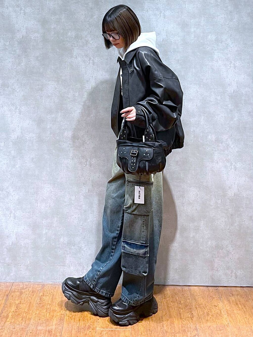 ブラック系のスニーカー、ブラック系のブルゾン、ブルー系のデニムパンツを着用したレディースの秋コーディネートの2枚目の写真