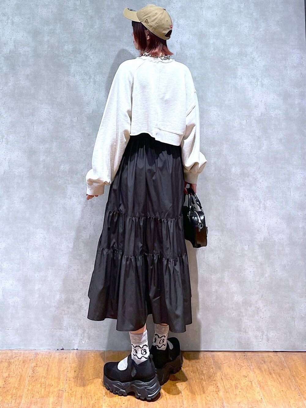 ベージュ系のスウェット、ブラック系のスニーカー、ブラック系のボストンバッグを着用したレディースの春コーディネートの5枚目の写真