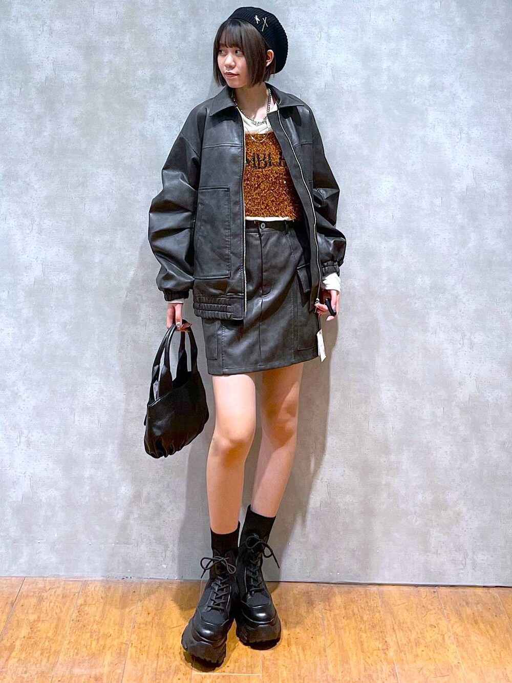 ブラック系のブーツ、ブラック系のブルゾン、ブラウン系のTシャツ/カットソーを着用したレディースの秋コーディネートの6枚目の写真
