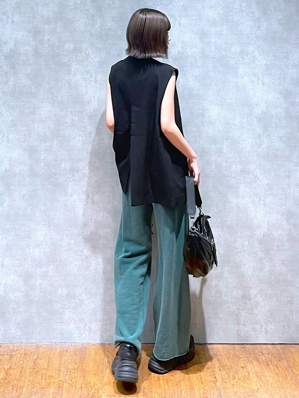 ホワイト系のタンクトップ、ブラック系のスニーカー、ブラック系のショルダーバッグを着用したレディースの夏コーディネートの3枚目の写真