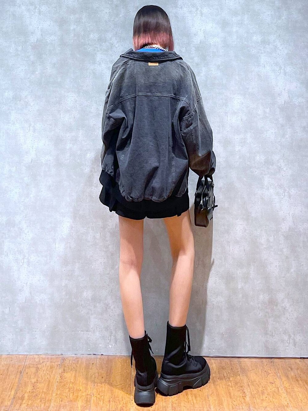 ブルー系のスウェット、ブラック系のデニムジャケット、ブラック系のその他パンツを着用したレディースの冬コーディネートの4枚目の写真