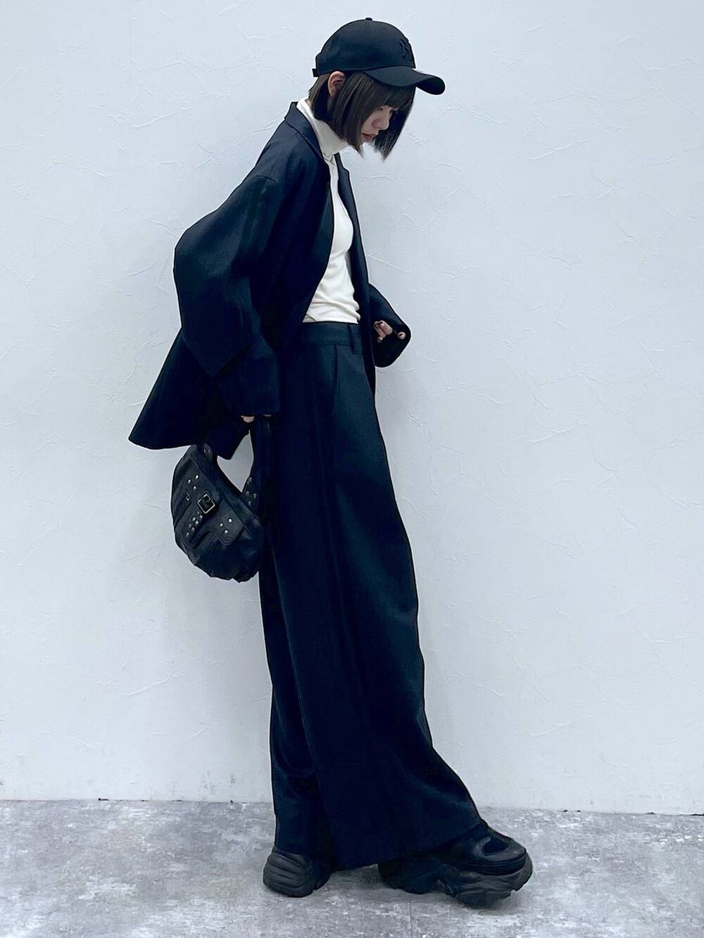 ブラック系のスニーカー、ブラック系のスラックス、ブラック系のテーラードジャケットを着用したレディースの秋コーディネートの4枚目の写真