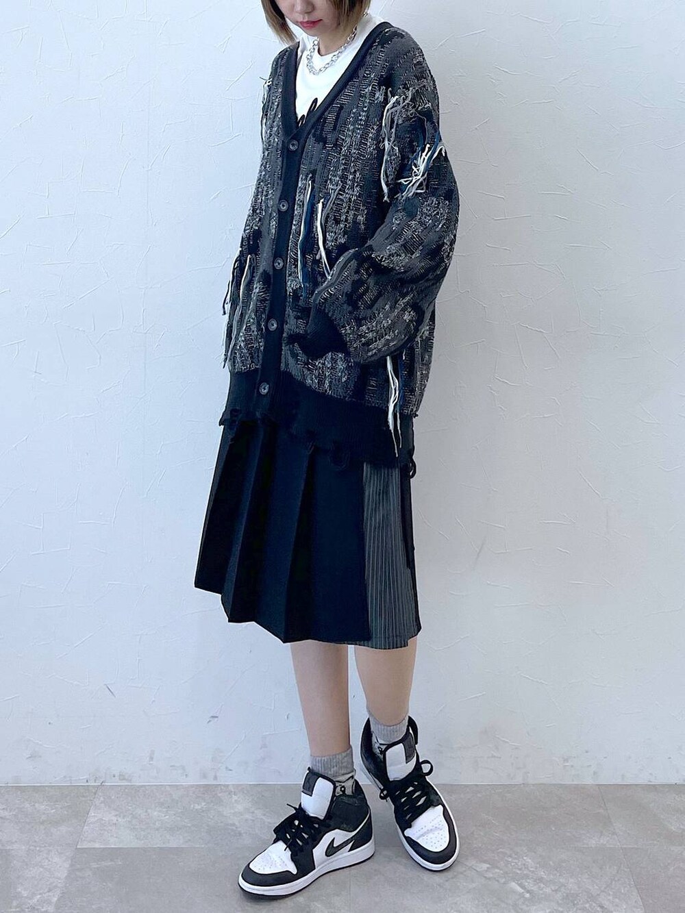 ブラック系のスラックス、ブラック系のカーディガン/ボレロ、シルバー系のネックレスを着用したレディースの冬コーディネートの2枚目の写真