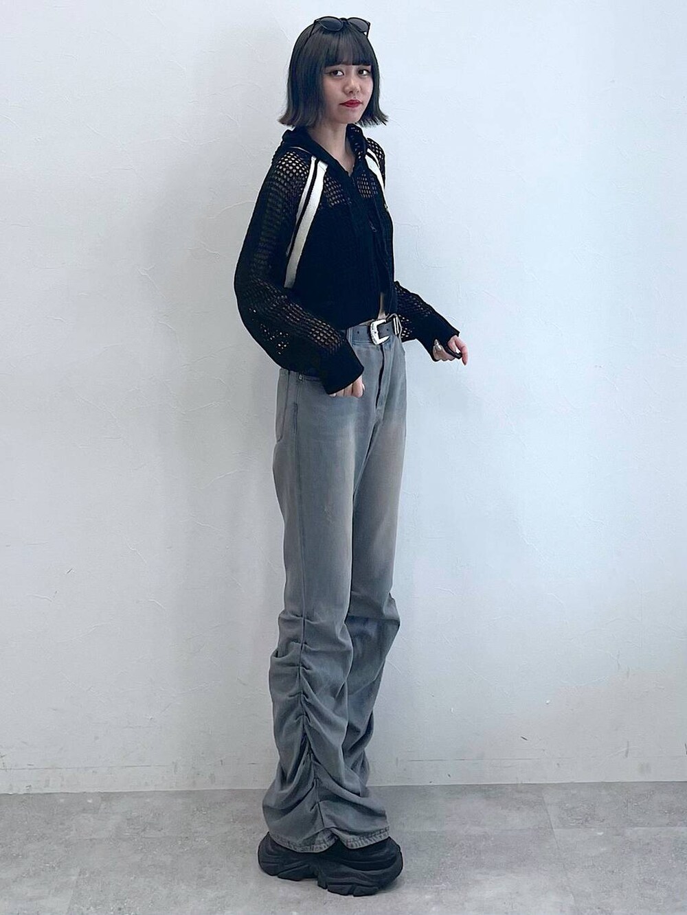 ブラック系のスニーカー、ブラック系のキャミソール、ブルー系のデニムパンツを着用したレディースの夏コーディネートの2枚目の写真