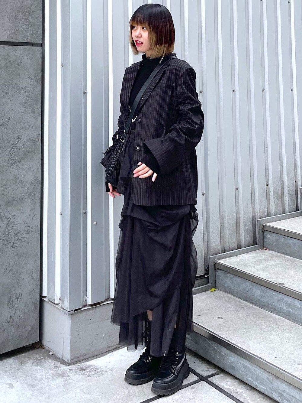 その他のテーラードジャケット、ブラック系のショルダーバッグ、ブラック系のブーツを着用したレディースの冬コーディネートの5枚目の写真