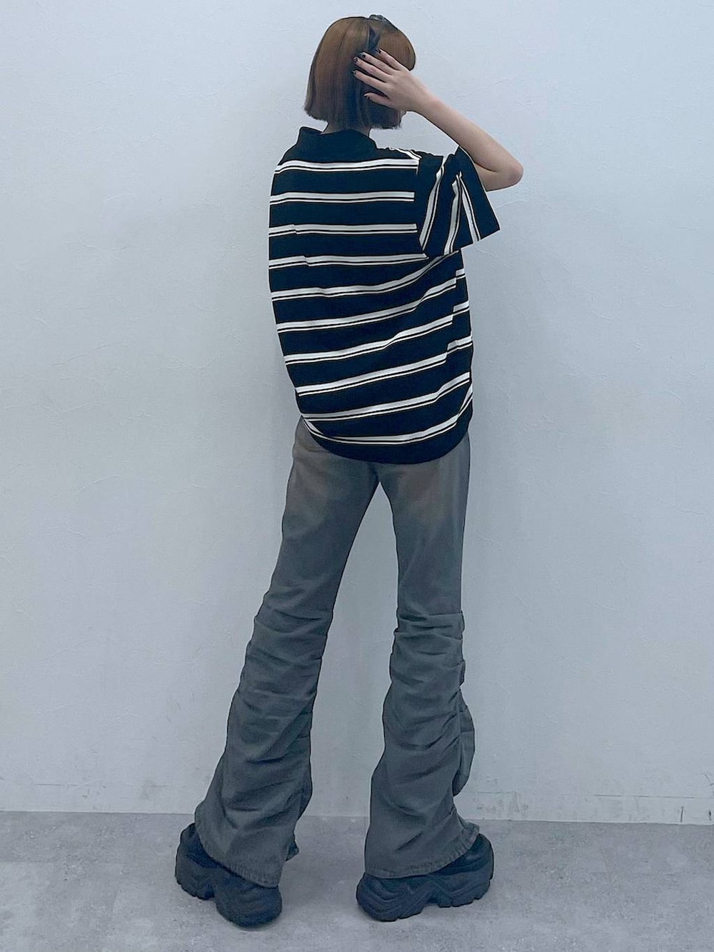 ブラック系のスニーカー、ブラック系のTシャツ/カットソー、ブルー系のデニムパンツを着用したレディースの夏コーディネートの6枚目の写真