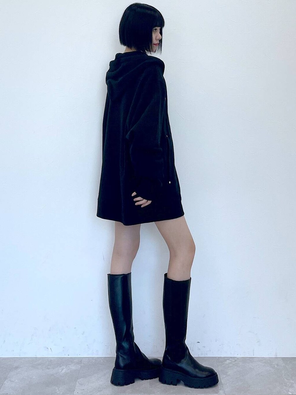 ブラック系のパーカー、ブラック系のブーツ、ブラック系のその他パンツを着用したレディースの冬コーディネートの3枚目の写真