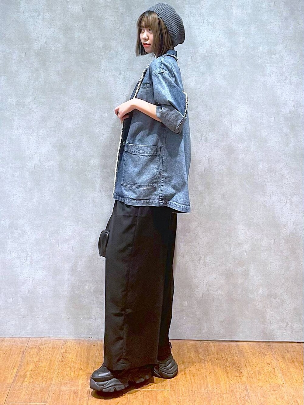 ブラック系のスニーカー、ブルー系のテーラードジャケット、ブラック系のキャミソールを着用したレディースの秋コーディネートの3枚目の写真