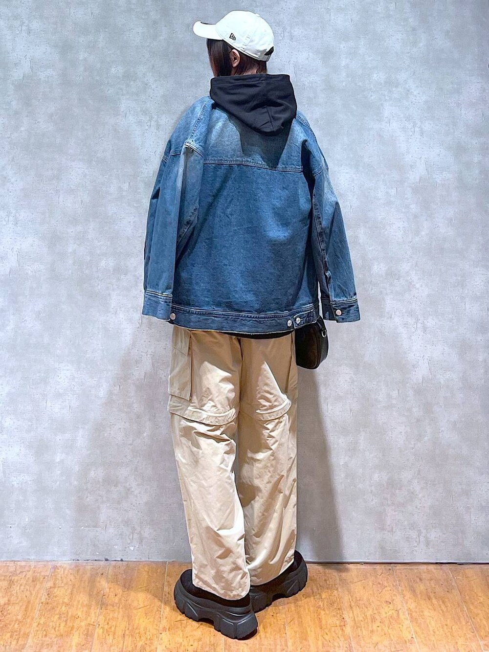 ブルー系のデニムジャケット、ベージュ系のカーゴパンツ、ブラック系のボストンバッグを着用したレディースの春コーディネートの5枚目の写真