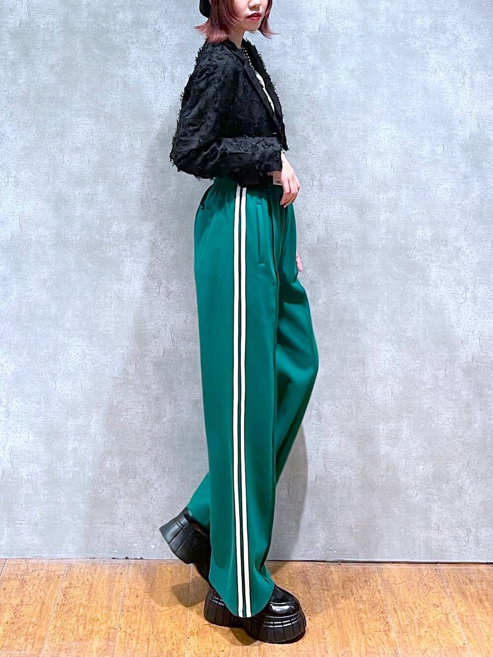 ブラック系のテーラードジャケット、グリーン系のその他パンツ、ブラック系のローファーを着用したレディースの春コーディネートの6枚目の写真