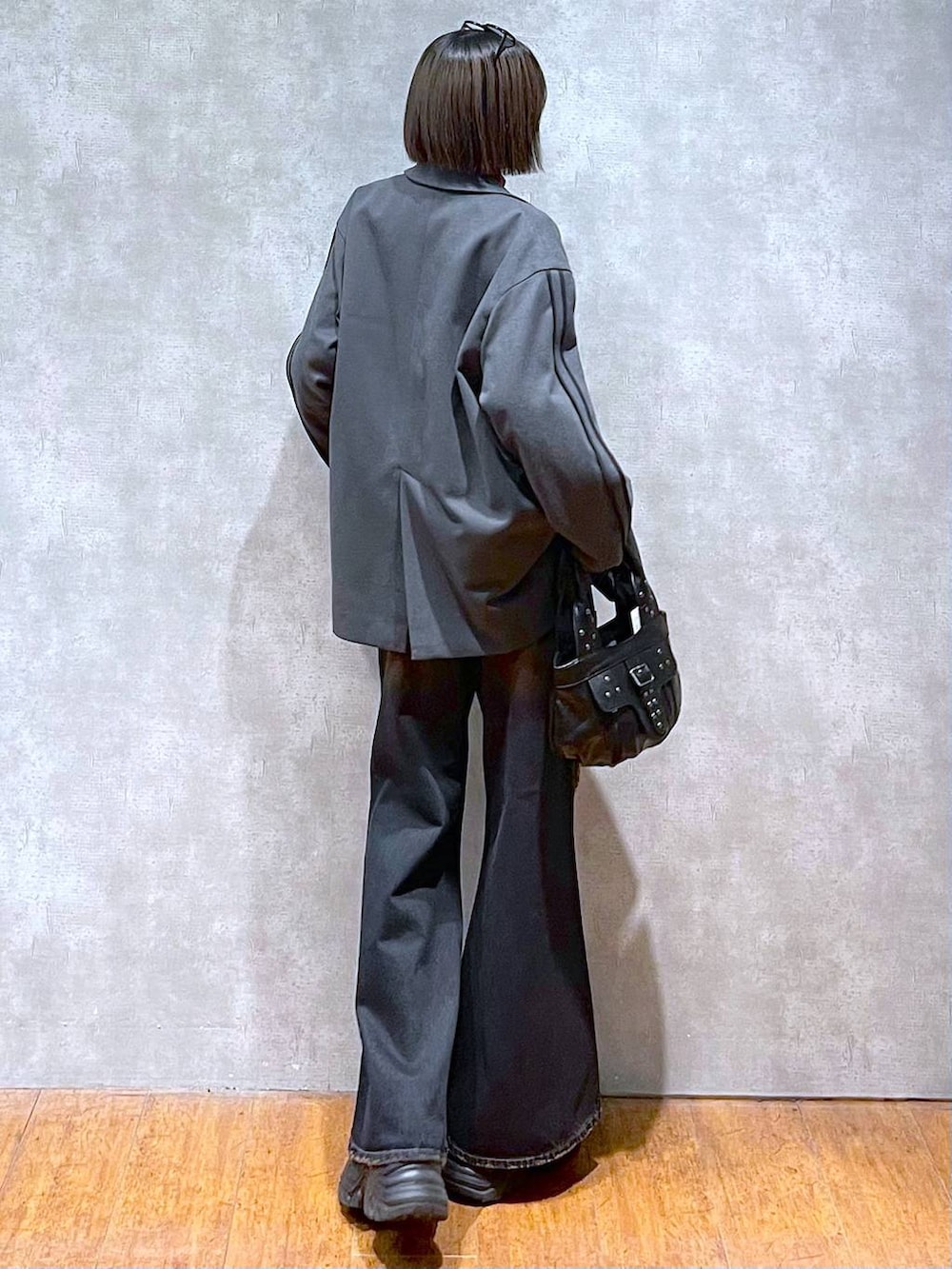 ブラック系のスニーカー、レッド系のニット/セーター、ブラック系のハンドバッグを着用したレディースの秋コーディネートの5枚目の写真