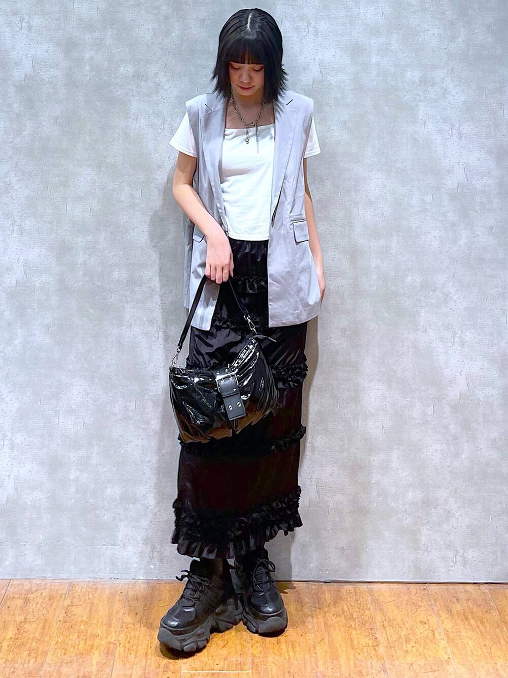 ブラック系のスニーカー、ホワイト系のTシャツ/カットソー、ブラック系のショルダーバッグを着用したレディースの夏コーディネートの6枚目の写真